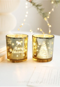 Détail de photophores de Noël en verre doré avec texte festif et motif de sapin de Noël