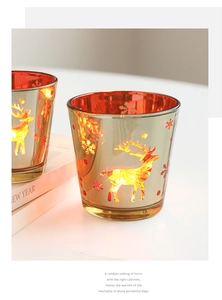 Détail de photophores festifs en verre avec motifs découpés de renne et flocon de neige