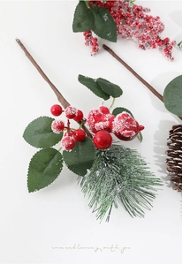 Macro shot of artificial red berries and snow-covered pine needles for holiday decor