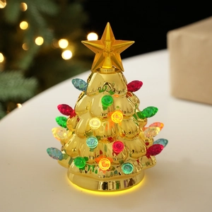 Close-up of golden mirror Christmas tree desk lamp with colorful LED lights and star topper