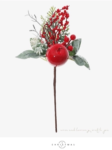 Close-up of artificial red apple and berries with snowy pine needles for Christmas decor