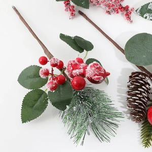 Artificial Christmas greenery pick with pine cones and red berries covered in fake snow