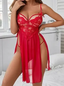 Détail de la nuisette rouge en tulle avec dentelle et fentes latérales sur tissu transparent