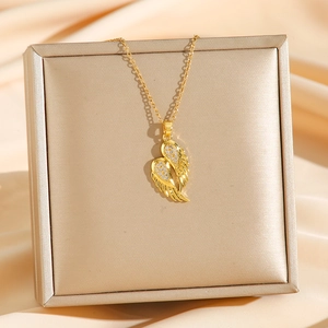 Collier pendentif ailes d'ange dorées avec zircons sur fond de soie couleur champagne