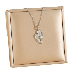 Collier pendentif cœur ailes d'ange avec zircons sur une boîte à bijoux dorée