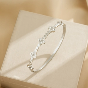 Silver stainless steel clover bangle with crystals displayed on a premium jewelry box