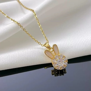 Gold plated rabbit necklace set with cubic zirconia pendant on elegant silk background