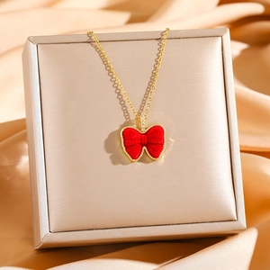 Collier élégant en acier titane doré avec pendentif nœud en velours rouge et cristaux