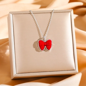 Collier élégant en acier titane avec pendentif nœud en velours rouge et diamants brillants