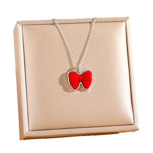 Collier en acier titane avec pendentif nœud en velours rouge et bordure en diamants