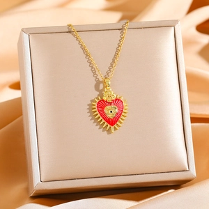 Collier gothique doré avec pendentif sacré-cœur et rose sur un fond de soie élégant