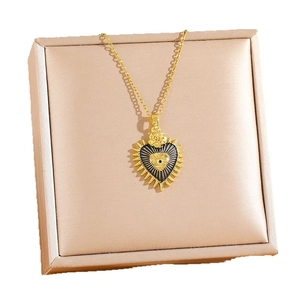 Collier gothique doré avec pendentif cœur, œil de démon et rose sur boîte à bijoux