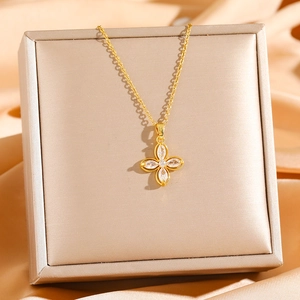 Detail of gold four-leaf clover necklace with sparkling cubic zirconia on silk