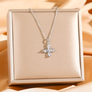 Elegant silver four-leaf clover pendant necklace with sparkling zircons on a jewelry box