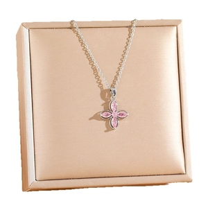 Silver four-leaf clover necklace with pink gems on a champagne satin jewelry box