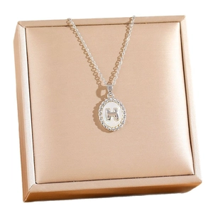 Silver H letter pendant necklace with shell inlay on champagne jewelry box display