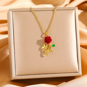Luxurious rose flower necklace with red flocking petals and gold chain on satin cloth