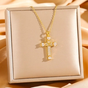 Gold plated cross necklace with micro-paved cubic zirconia crystals on a luxury satin background