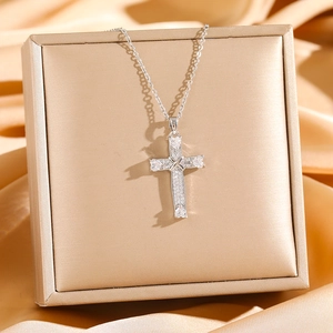 Cross pendant necklace with micro-paved zircons and heart-cut stones on silk fabric