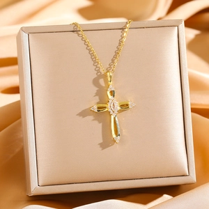 Gold hollow cross necklace with zircon centerpiece on champagne satin jewelry box