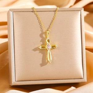 Elegant gold titanium cross necklace with pink crystal and zircon on luxury satin backdrop
