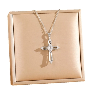 Elegant hollow cross necklace with sparkling zircons on a white jewelry box