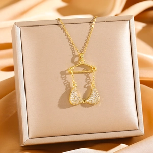 Golden bikini pendant necklace with sparkling zircons displayed in a luxury gift box