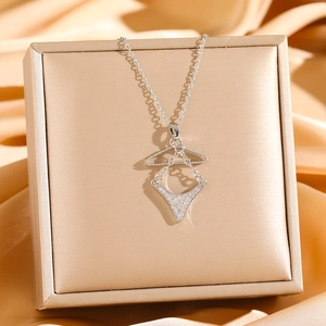 Close-up of creative bikini hanger pendant necklace with sparkling cubic zirconia on satin