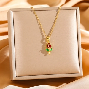 Detail of tulip pendant with red zircon stone and green enamel leaf on golden chain