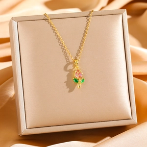 Elegant gold tulip pendant necklace with pink and green crystals on a silk background