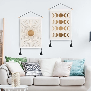 Boho sun and moon wall tapestries with wooden rod and black tassels on white wall
