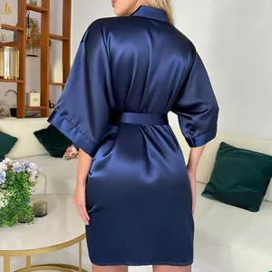 Détail d'un peignoir en satin bleu marine avec ceinture nouée et fini brillant élégant