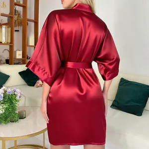 Vue arrière d'un peignoir en satin bordeaux brillant avec manches larges à la maison