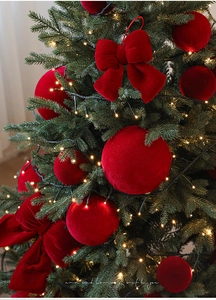 Detail of red flocked Christmas ornaments set featuring velvet balls and large bow decoration