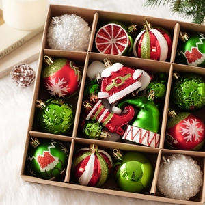 Primer plano de adornos navideños rojos y verdes con botas de Papá Noel en caja de regalo