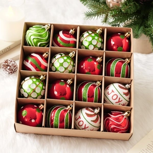 Detalle de 16 bolas de Navidad rojas y verdes en caja con diseños JOY y ganchos dorados
