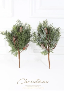 Detailansicht künstlicher Weihnachtskiefernzweige mit Tannenzapfen und Kunstschnee