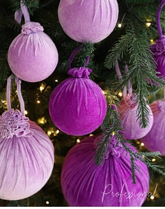 Vue détaillée de boules de Noël en velours bordeaux floqué sur le sapin décoratif