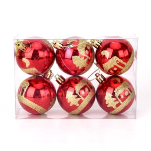 Detailed view of red Christmas ornaments with gold painted snow house and forest designs