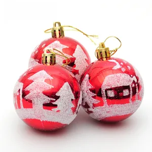 Detail of red Christmas balls with white glitter snow landscape and gold hangers