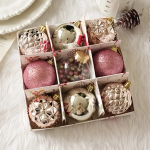 Detalle del set de 9 bolas de Navidad con texturas variadas en caja de regalo
