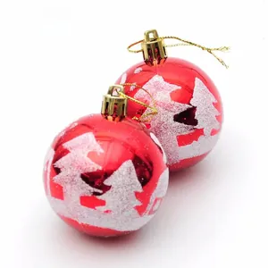Detail of red Christmas ornaments with white snow-flocked tree prints and golden strings