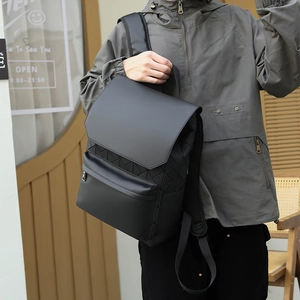 Detail of black backpack featuring geometric 3D triangle texture and flap closure design