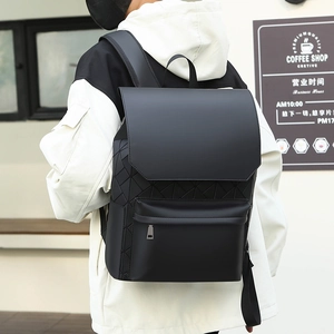Outdoor view of a black matte geometric backpack with a minimalist flap cover design