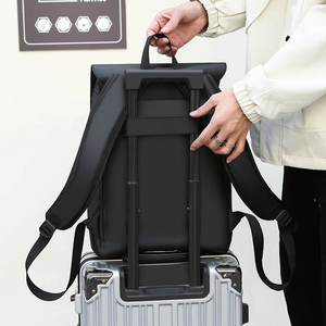 Detail of the black laptop backpack with luggage strap fixed on a suitcase handle