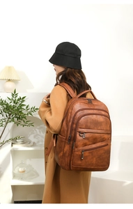 Détails d'un grand sac à dos vintage en cuir marron avec plusieurs poches zippées
