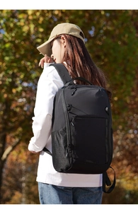 Close-up of waterproof nylon material and front zipper pocket on black commuter backpack
