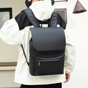 Detail of matte black backpack featuring geometric rhombus texture and front zipper pocket