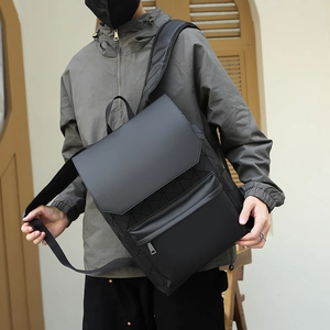 Detail of black business backpack with 3D geometric embossed texture and flap cover