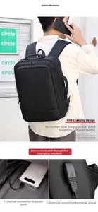 Detalle del puerto de carga USB externo y tejido resistente al agua en la mochila negra
